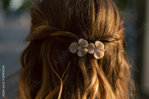 beautiful plastic hairpin delicate peach color with flowers for the bride on the girl s hair. wedding accessory