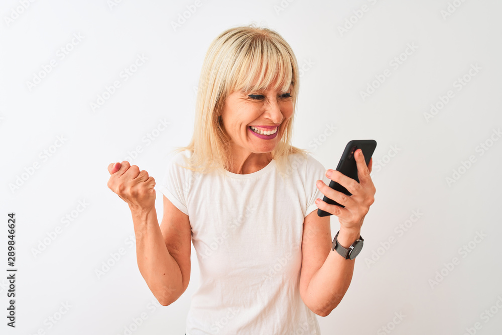 Middle age woman using smartphone standing over isolated white background screaming proud and celebrating victory and success very excited, cheering emotion Middle age woman using smartphone standing over isolated white background screaming proud and celebrating victory and success very excited, cheering emotion