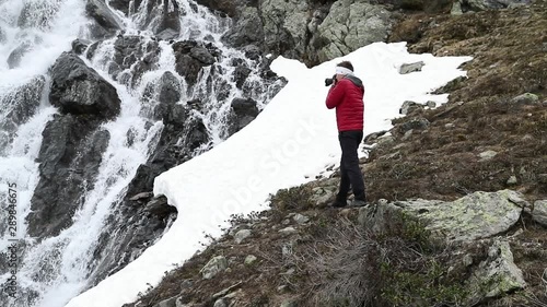 Photographer takes picture of waterfall near Susch pass near Davos in Switzerlang. Shot was made in slow motion in June. photo