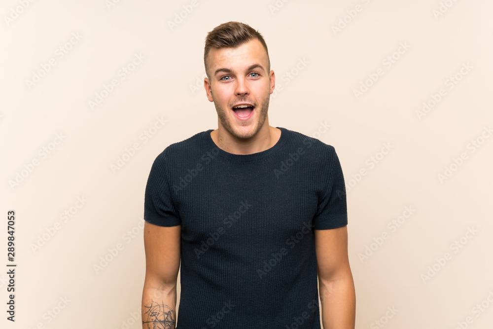 Young handsome blonde man over isolated background with surprise facial expression