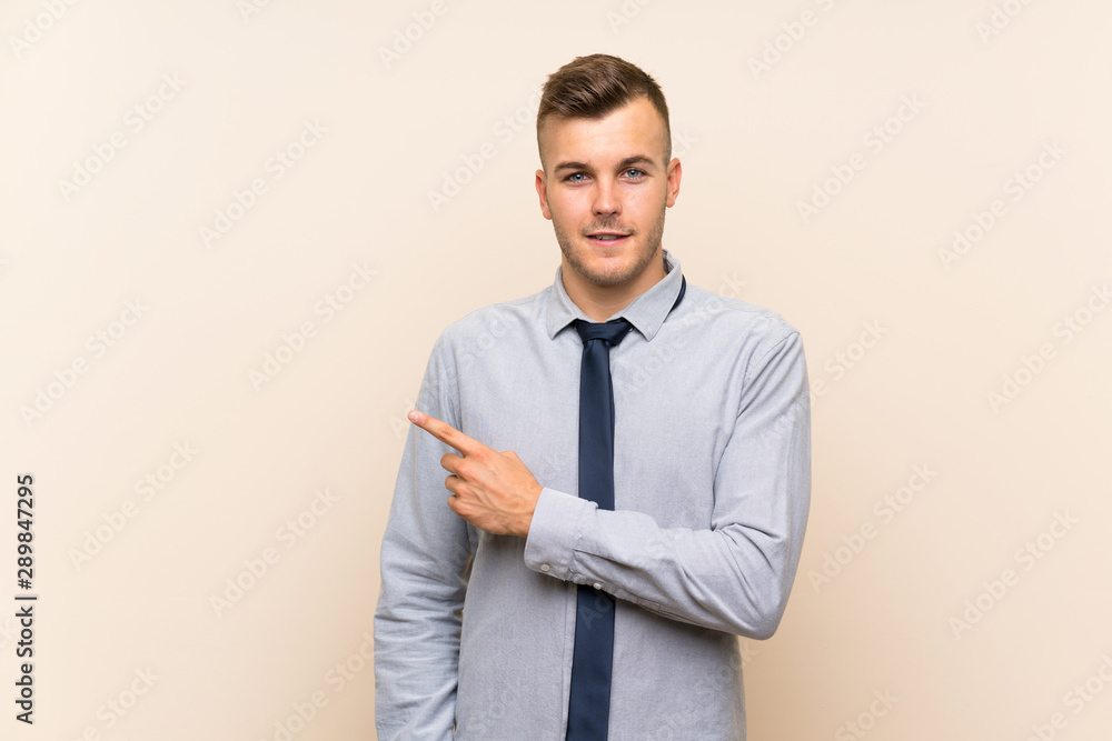 Young blonde businessman over isolated background pointing finger to the side Young blonde businessman over isolated background pointing finger to the side