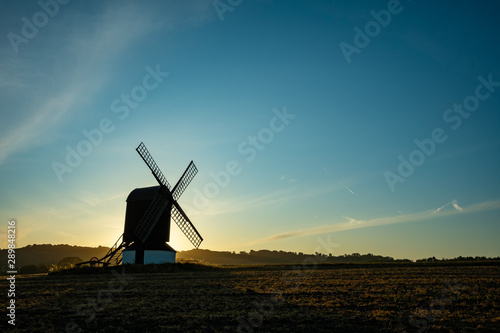 Windmill in a picture with sun rising behind nicely highlighting the mill structure