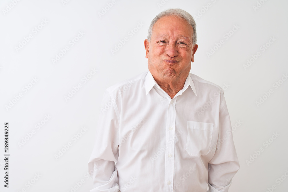 Senior grey-haired man wearing elegant shirt standing over isolated white background puffing cheeks with funny face. Mouth inflated with air, crazy expression. Senior grey-haired man wearing elegant shirt standing over isolated white background puffing cheeks with funny face. Mouth inflated with air, crazy expression.