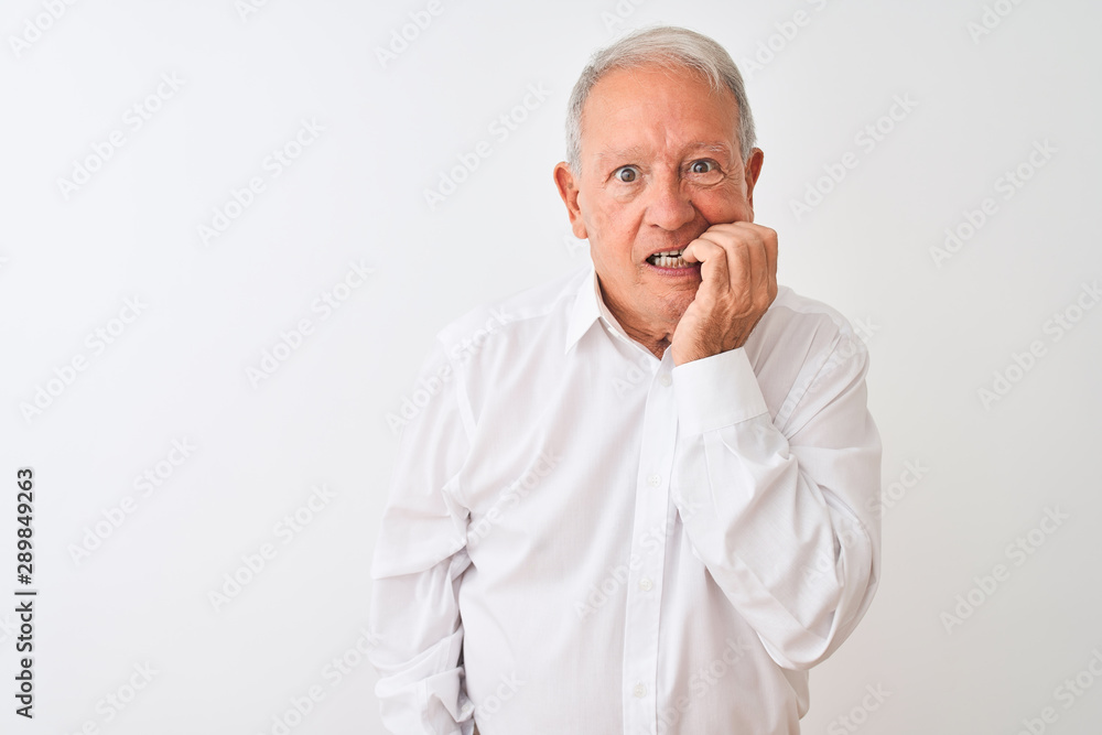 Obraz premium Senior grey-haired man wearing elegant shirt standing over isolated white background looking stressed and nervous with hands on mouth biting nails. Anxiety problem.