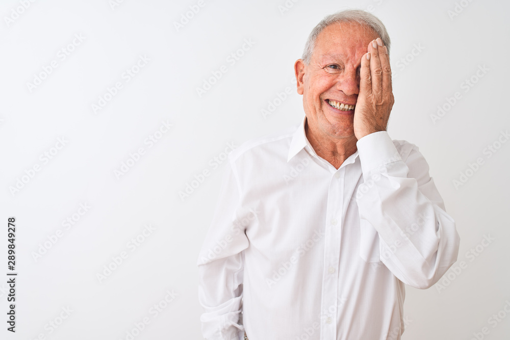 Obraz premium Senior grey-haired man wearing elegant shirt standing over isolated white background covering one eye with hand, confident smile on face and surprise emotion.