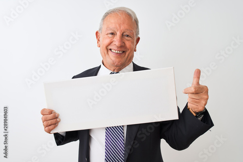 Senior businessman wearing suit holding banner over isolated white background happy with big smile doing ok sign, thumb up with fingers, excellent sign © Krakenimages.com