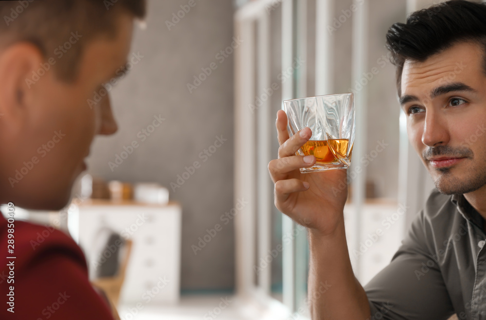 Young men drinking whiskey together at home Young men drinking whiskey together at home