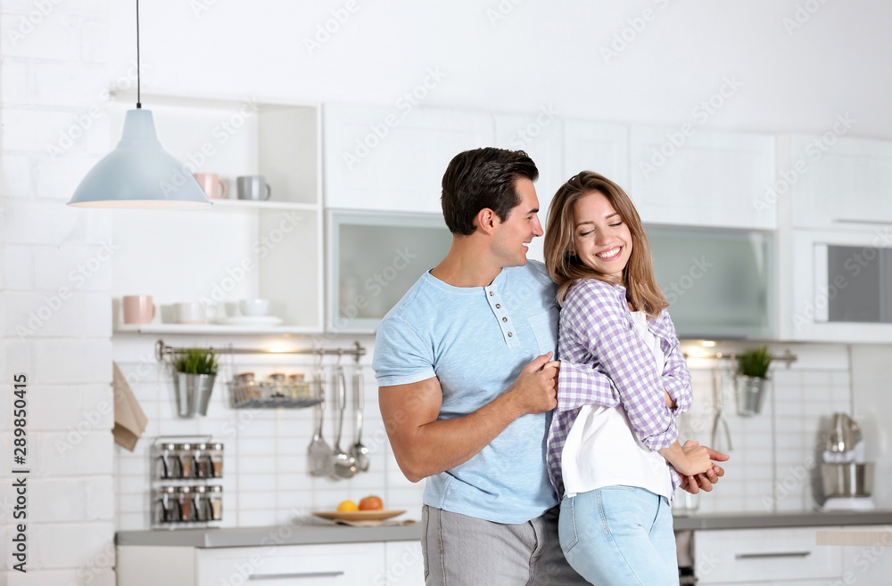 Beautiful young couple dancing in kitchen at home Beautiful young couple dancing in kitchen at home