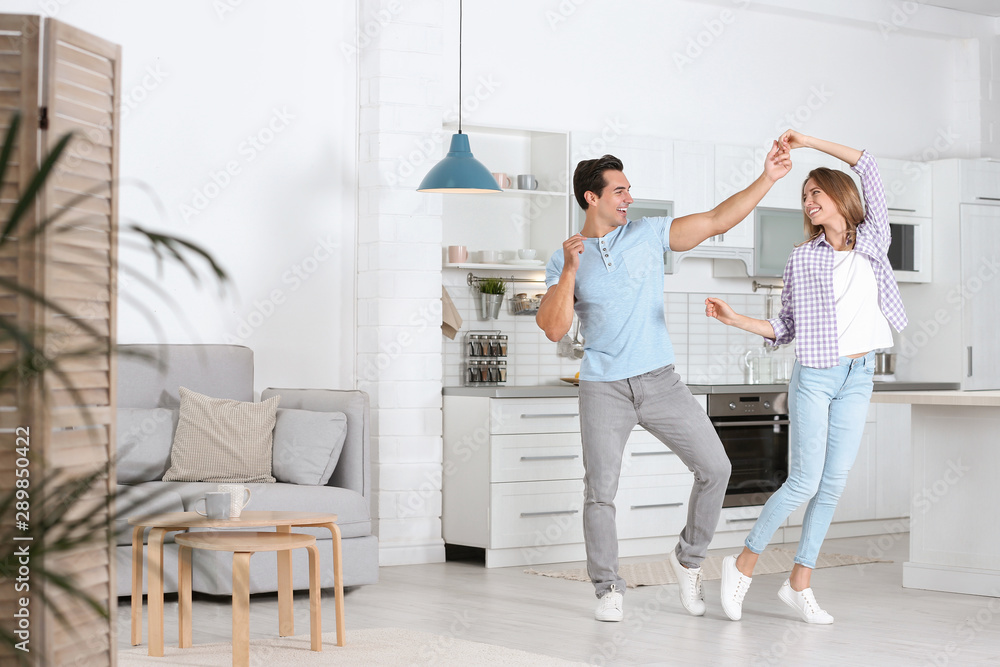 Beautiful young couple dancing in kitchen at home Beautiful young couple dancing in kitchen at home