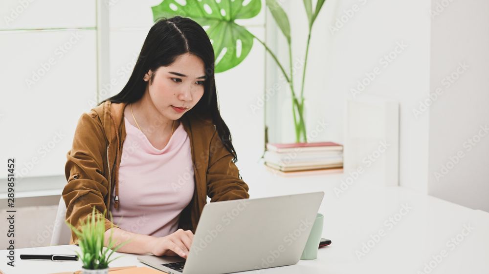 Young woman using laptop computer in modern office. Young woman using laptop computer in modern office.