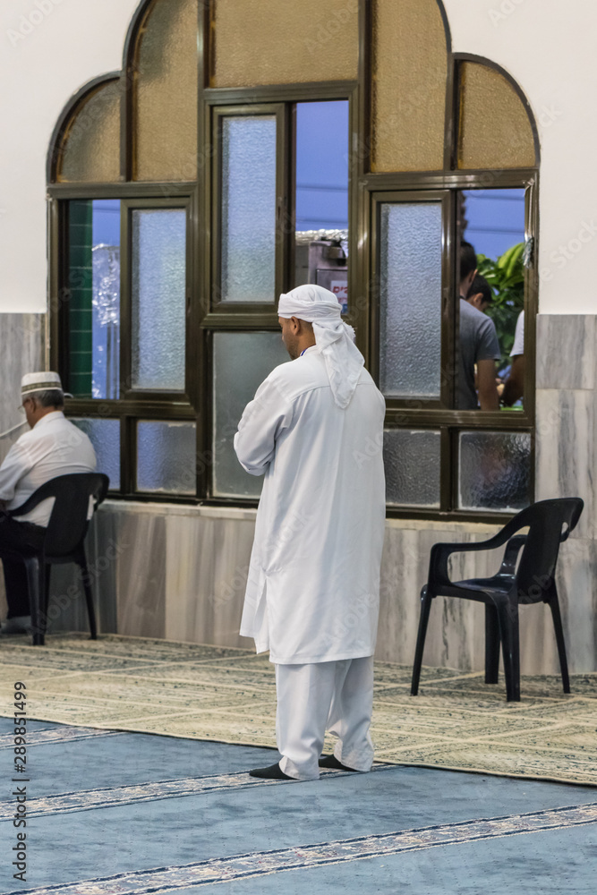Obraz premium Muslim believer prays in prayer room of the Ahmadiyya Shaykh Mahmud mosque in Haifa city in Israel