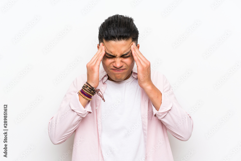 Young man over isolated white wall unhappy and frustrated with something. Negative facial expression Young man over isolated white wall unhappy and frustrated with something. Negative facial expression