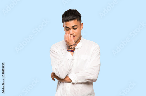 Young man having doubts on colorful background