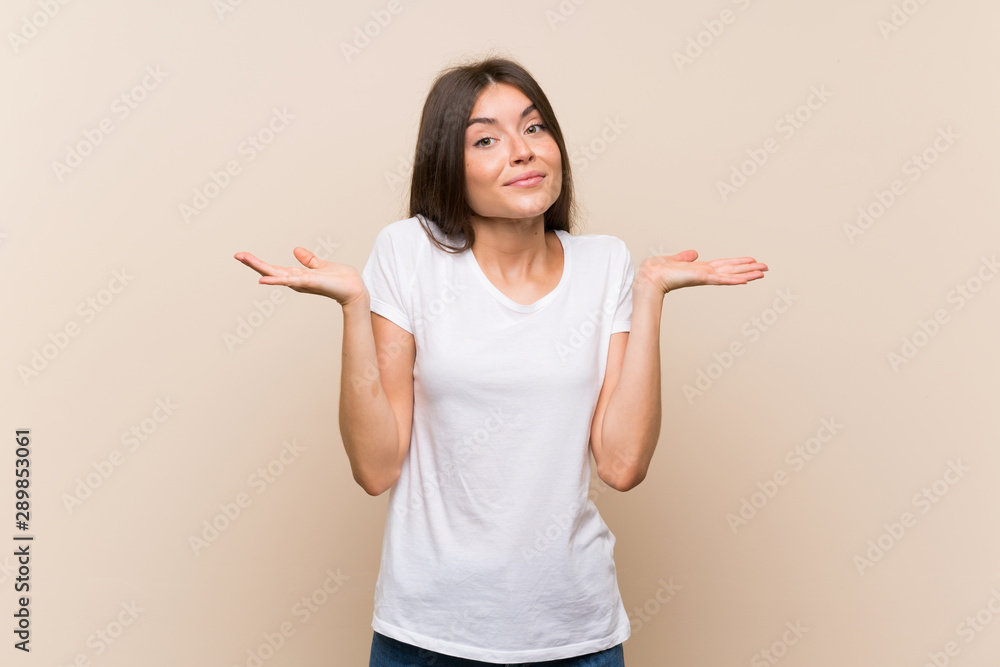 Pretty young girl over isolated background making doubts gesture Pretty young girl over isolated background making doubts gesture