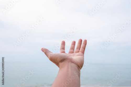 Man open hand raise up on sky background at beach. Freedom feel good concept. © tonktiti