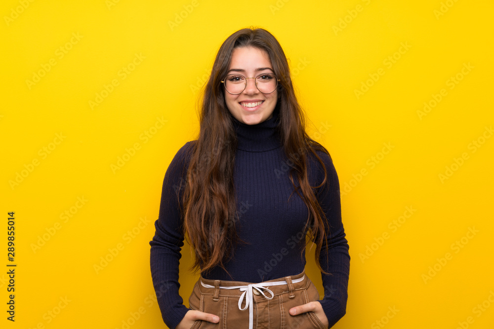 Teenager girl over isolated yellow wall laughing Teenager girl over isolated yellow wall laughing
