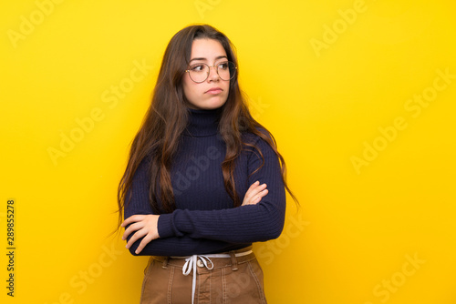 Teenager girl over isolated yellow wall portrait