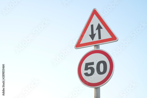 Road sign with a blue sky on background. Traffic signpost.