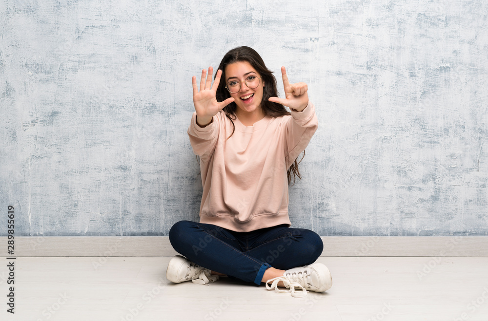 Teenager student girl studying in a table counting seven with fingers Teenager student girl studying in a table counting seven with fingers
