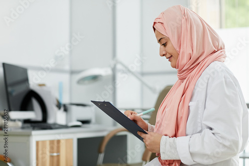 Photography Side view portrait of Middle-Eastern woman wearing hijab working as nurse in med