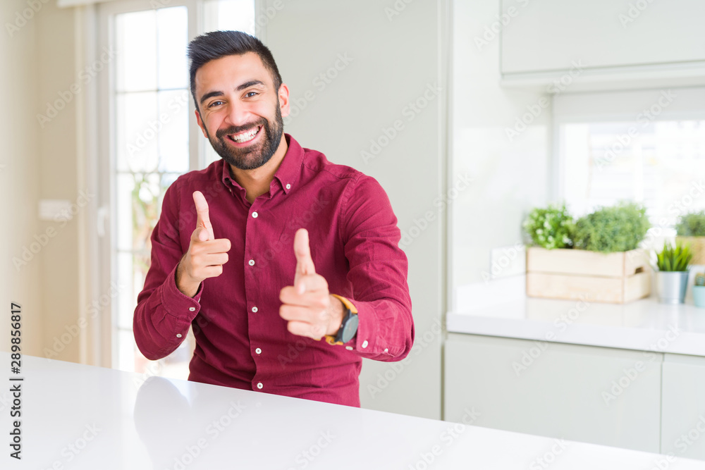 Handsome hispanic business man pointing fingers to camera with happy and funny face. Good energy and vibes. Handsome hispanic business man pointing fingers to camera with happy and funny face. Good energy and vibes.