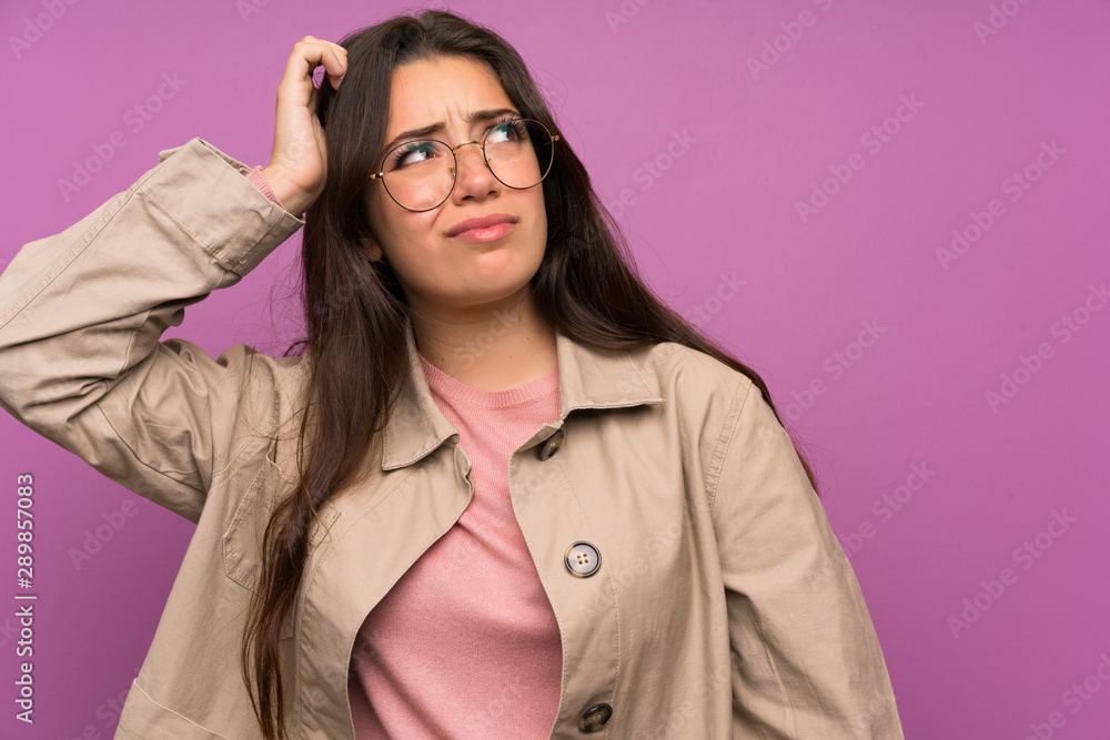 Teenager girl over purple wall having doubts and with confuse face expression Teenager girl over purple wall having doubts and with confuse face expression