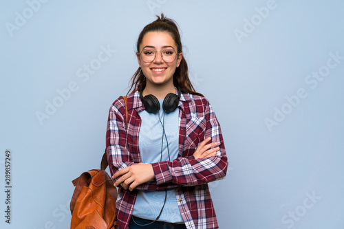 Fotografia Teenager student girl over isolated blue wall keeping the arms crossed in fronta
