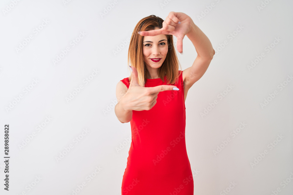 Redhead businesswoman wearing elegant red dress standing over isolated white background smiling making frame with hands and fingers with happy face. Creativity and photography concept. Redhead businesswoman wearing elegant red dress standing over isolated white background smiling making frame with hands and fingers with happy face. Creativity and photography concept.