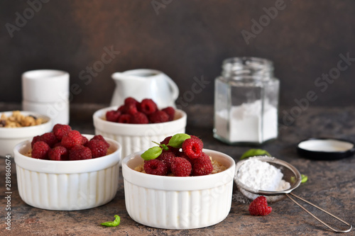 Cheesecake - The classic dessert cheese cream with raspberries. Dessert on the kitchen table. Souffle with cream and berries.