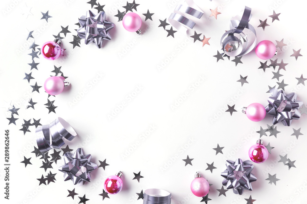 Christmas border of silver and pink pastel decoration, balls , tinsel, star, glitter on white. Xmas background. Flat lay style. Top view with copy space