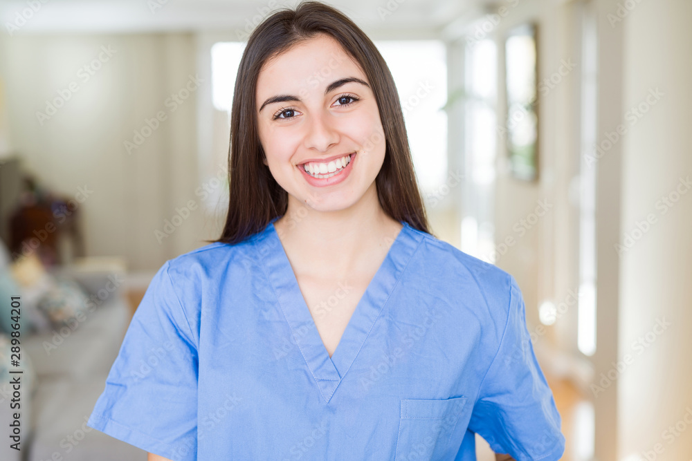Beautiful young nurse woman at the clinic with a happy and cool smile on face. Lucky person. Beautiful young nurse woman at the clinic with a happy and cool smile on face. Lucky person.