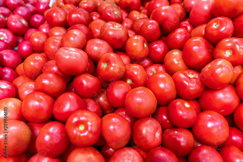 Close-up view of fresh juicy tomatoes  background photography. Summer agriculture farm market tray full of organic tomatoes.