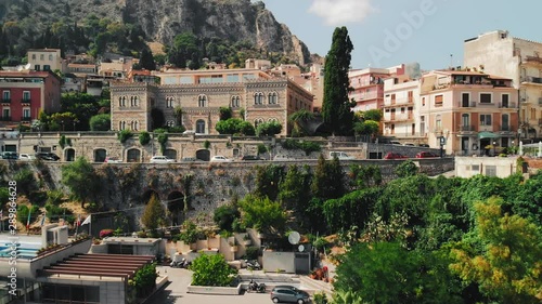 Taormina, SICILY, Italy - August 2019: beautiful mountain town located on the rocky mountains. In the background is a volcano. Unrecognized shops and unrecognized expensive hotels with a pool move
