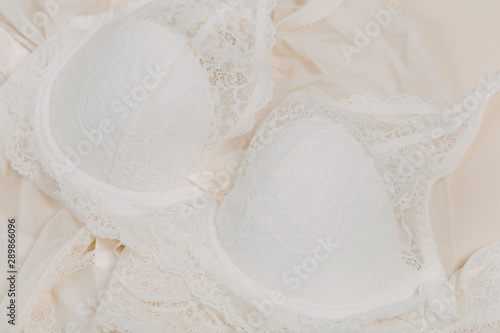 White women underwear with lace on beige background. whitebra and pantie.Copy space. Beauty, fashion blogger concept. Romantic lingerie for Valentine's day temptation. Erotic concept.