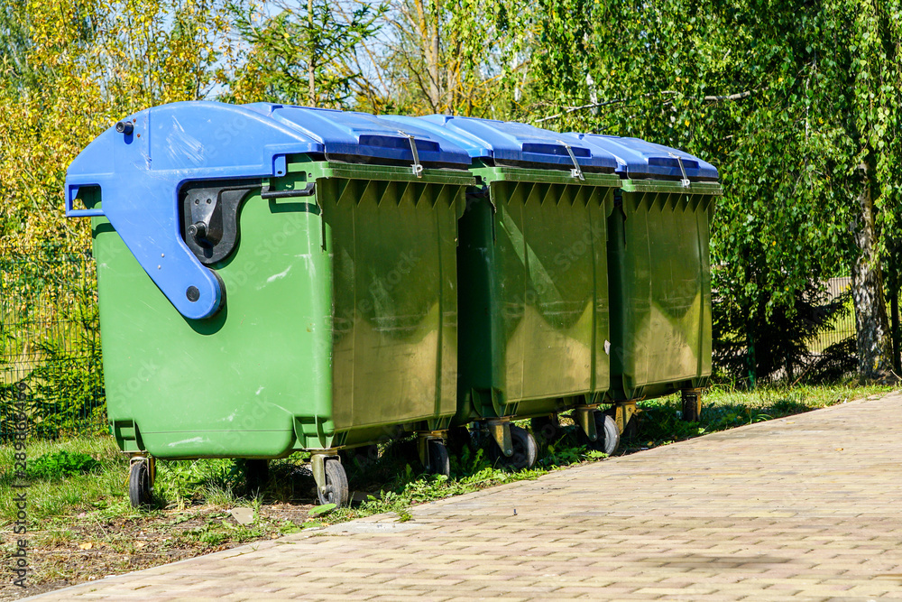 three large green plastic waste bins on wheels three large green plastic waste bins on wheels