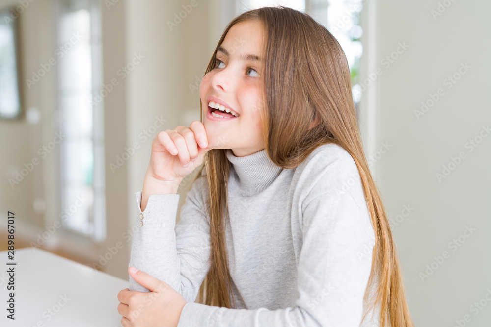 Beautiful young girl kid wearing turtleneck sweater with hand on chin thinking about question, pensive expression. Smiling with thoughtful face. Doubt concept. Beautiful young girl kid wearing turtleneck sweater with hand on chin thinking about question, pensive expression. Smiling with thoughtful face. Doubt concept.