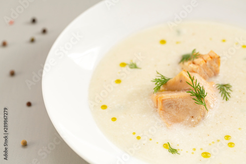 Finnish creamy soup with wild salmon. A bowl of creamy soup with salmon. Healthy food. Close up, selective focus. 