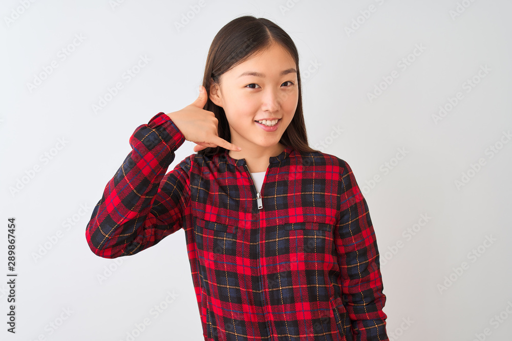 Young chinese woman wearing casual jacket standing over isolated white background smiling doing phone gesture with hand and fingers like talking on the telephone. Communicating concepts. Young chinese woman wearing casual jacket standing over isolated white background smiling doing phone gesture with hand and fingers like talking on the telephone. Communicating concepts.