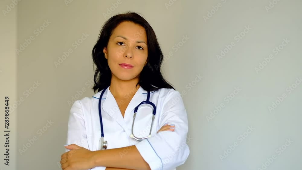 Slow motion close up of a beautiful young woman Lady Doctor Looking at Camera. Concept of profession, medicine and healthcare, medical education. Slow motion close up of a beautiful young woman Lady Doctor Looking at Camera. Concept of profession, medicine and healthcare, medical education.