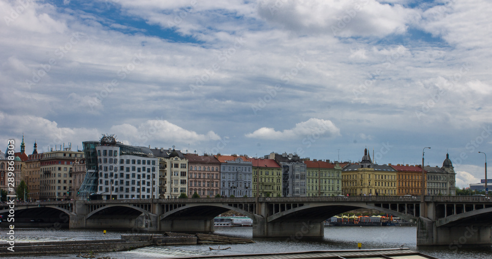 Panoramic of buildings with famous dancing house in Prague, with Vltava river