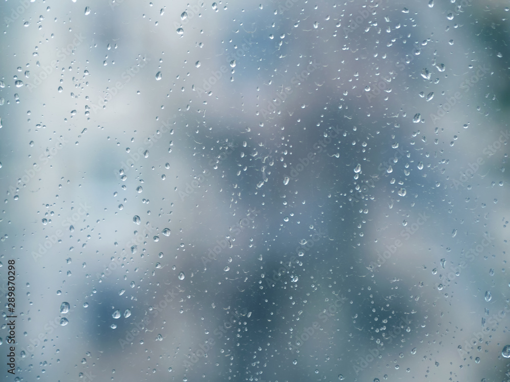 ..Raindrops on the surface of window glass with a blurred background.