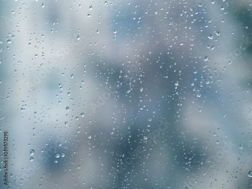 ..Raindrops on the surface of window glass with a blurred background.