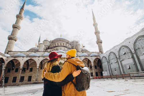 Photography A young European couple walks in the courtyard of the Blue Mosque in Istanbul, Turkey