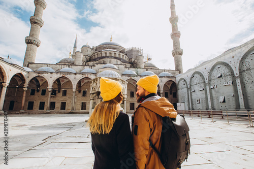 Photography A young European couple walks in the courtyard of the Blue Mosque in Istanbul, Turkey