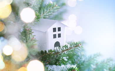Christmas fir tree branches with house Christmas ornaments on blurred blue background. Christmas and Winter concept.