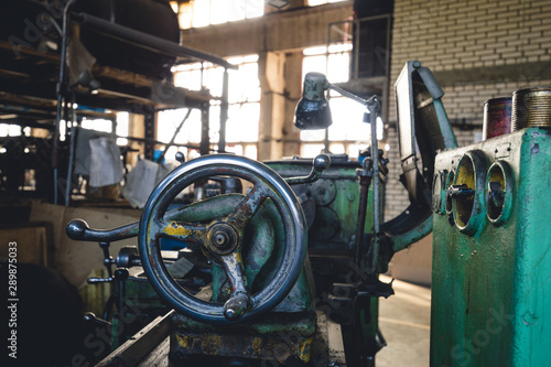 Rusty mechanisms and tools in the shop of an old abandoned factory.