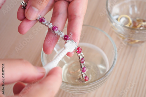 Jeweller hand cleaning and polishing vintage jewelry red ruby bracelet closeup