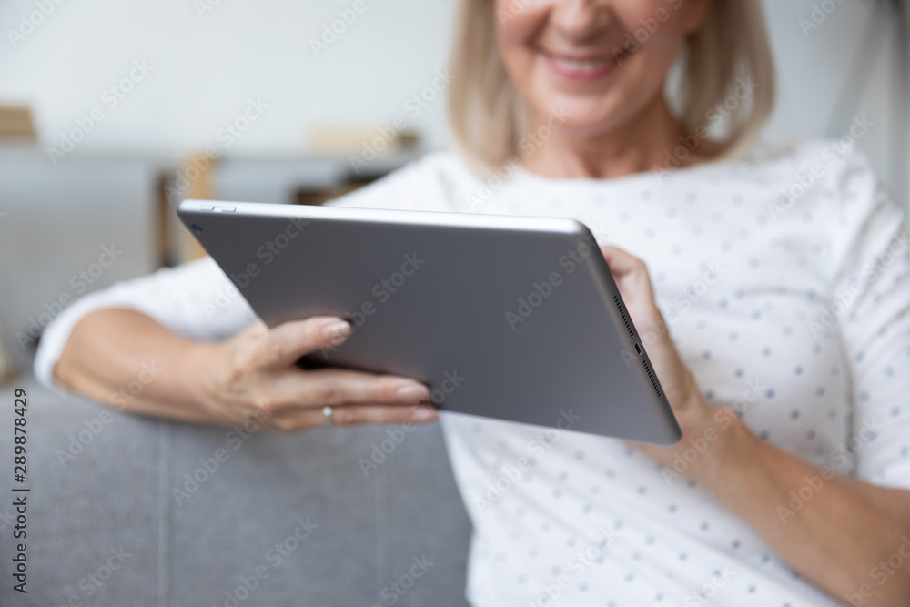 Smiling mature woman using computer tablet close up Smiling mature woman using computer tablet close up