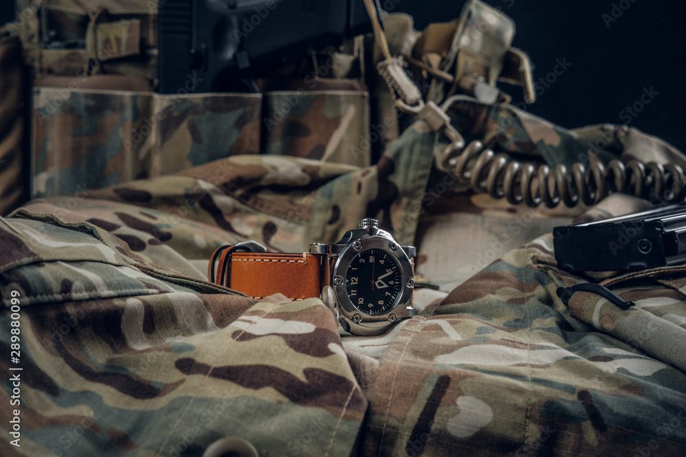 Still life with nice watch and military uniform with typical camo pattern. Still life with nice watch and military uniform with typical camo pattern.