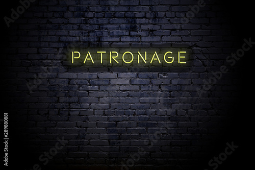 Highlighted brick wall with neon inscription patronage